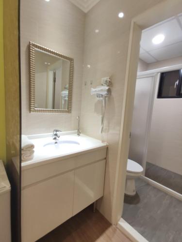 a bathroom with a sink and a toilet and a mirror at Donghae13.8 in Longjing