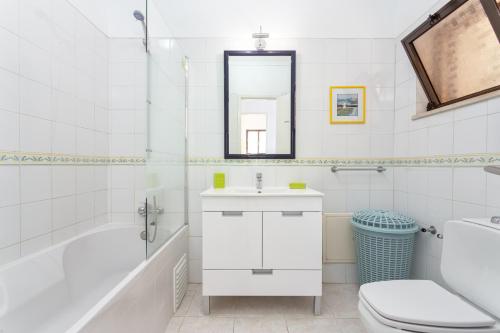 a bathroom with a sink and a tub and a toilet at Fresh Sunny Flat with Pool & Terrace by Host Wise in Albufeira