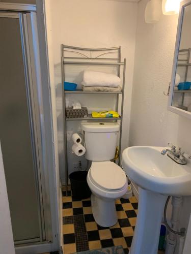 a bathroom with a white toilet and a sink at Design District Retreat in Miami