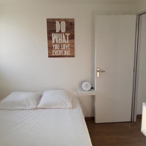 - une chambre avec un lit blanc et un panneau mural dans l'établissement Ty Breizh, à Erdeven