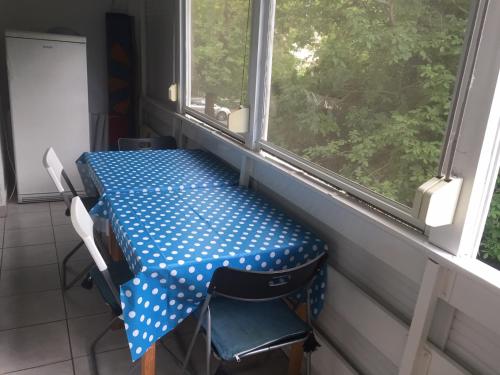 - une table et des chaises dans une chambre avec deux fenêtres dans l'établissement Lellei vízparti apartman homokos strandnál, à Balatonlelle