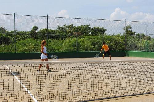two people playing tennis on a tennis court at Grand Sirenis Punta Cana Resort & Aquagames - All Inclusive in Punta Cana