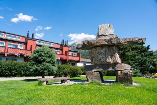 a stone statue and a bench in front of a building at Rocky Mountain Ski Lodge in Canmore