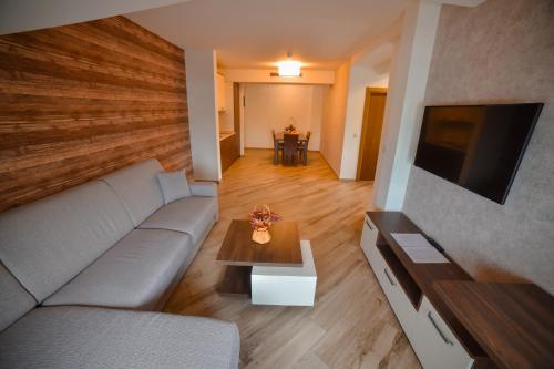 a living room with a couch and a tv and a table at Central Inn in Zlatibor