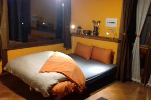 a bed in a room with a window at La Casina nella Valle in Serina