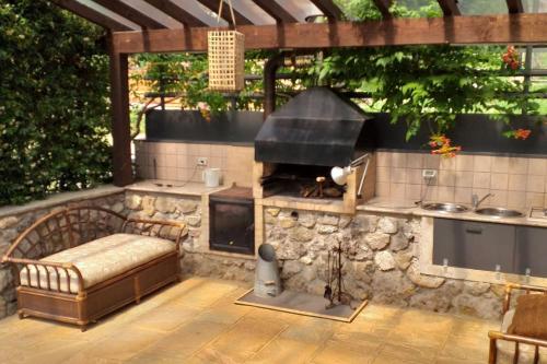 an outdoor kitchen with a couch and an oven at La Casina nella Valle in Serina
