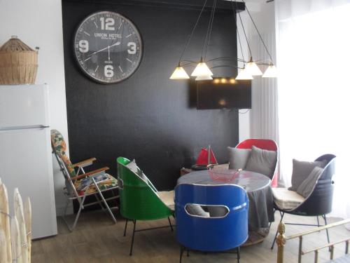 a kitchen with a table and a clock on the wall at Studio 21 in Lorient