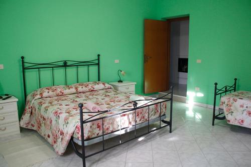 - une chambre avec un lit et un mur vert dans l'établissement Agriturismo Carnaroli, à Piagge