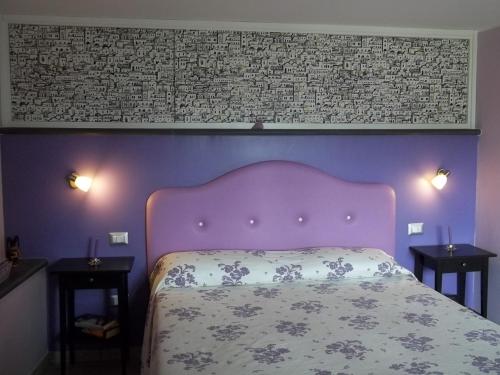 a purple bedroom with a bed and two night tables at B&B La Casetta Dei Nonni in Orvieto