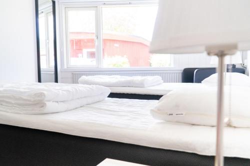 two beds with white pillows on them in a room at Karlskoga Folkhögskola Vandrarhem Udden in Karlskoga