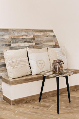 a bench with pillows and a coffee table at Alle Scalette B&B in Lauria
