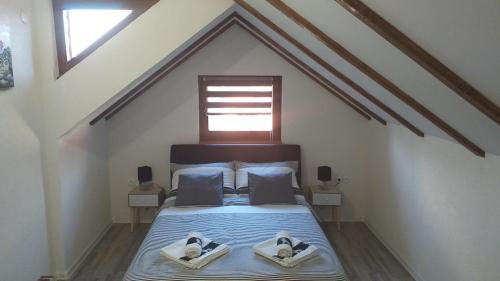 a bedroom with a bed with two towels on it at Studio Apartmani Patricia in Smoljanac