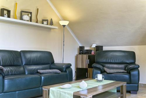 a living room with two leather couches and a coffee table at Ferienwohnung Bella in Fuhlendorf
