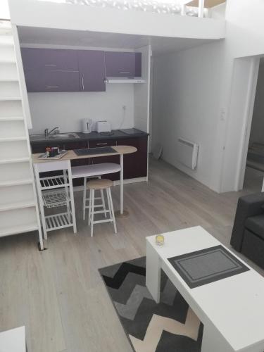 Il comprend un petit salon avec une cuisine et une table. dans l'établissement Le Duplex reseau Cycle gites, à Fleury-sur-Orne