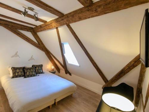 a attic bedroom with a bed and a tv at Beauty & The Beast - Old Town Cosy Apartments in Colmar