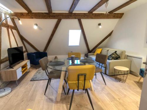 a living room with a table and chairs and a couch at Beauty & The Beast - Old Town Cosy Apartments in Colmar