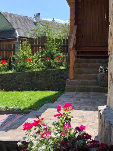 a garden with pink flowers and a house at Karpatska Mria in Yaremche