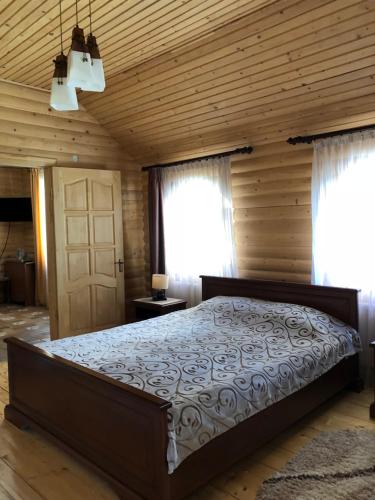 a bedroom with a bed and a wooden ceiling at Karpatska Mria in Yaremche