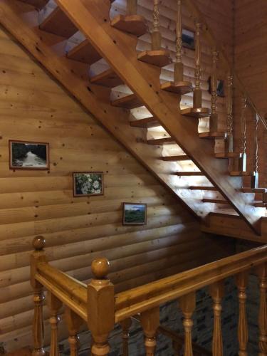 a staircase in a log cabin with a wooden ceiling at Karpatska Mria in Yaremche