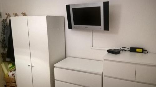 a room with a white cabinet and a tv on the wall at numero uno in Lido di Jesolo