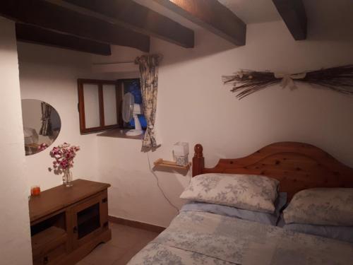 1 dormitorio con 1 cama y 1 mesa con flores en Gite de Lac Tranquille, en Plaud