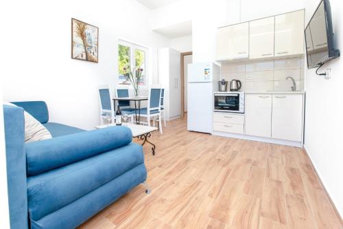 a living room with a blue couch and a kitchen at Apartments Golden View in Kotor