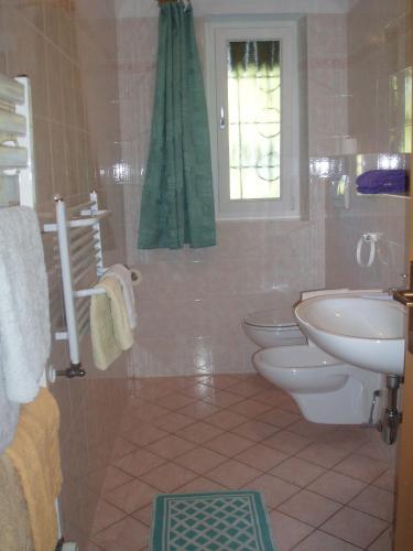 a bathroom with a sink and a toilet and a window at Dillerhof in Laion