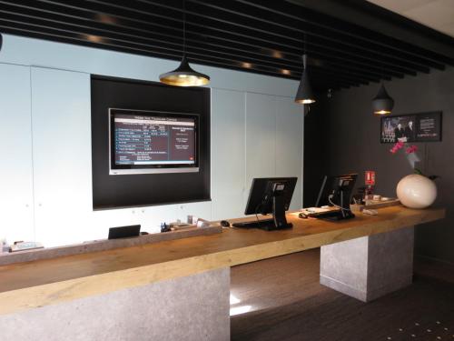a reception desk with a large screen on the wall at ibis Toulouse Centre in Toulouse
