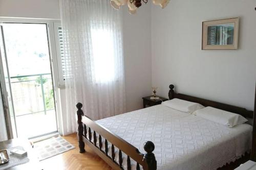 ein Schlafzimmer mit einem Bett und einem großen Fenster in der Unterkunft Apartments Racetin in Marina