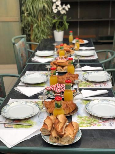 a long table with plates of food and bottles of juice at Hôtel De La Mare -restaurant pour les clients sur réservation in Avrigny