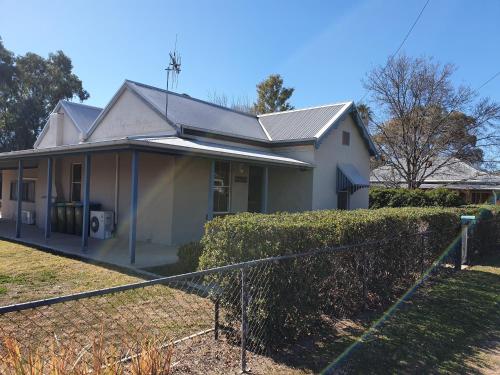 a white house with a fence in front of it at Denison Lodge in Mudgee