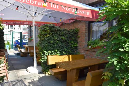 a table and benches outside of a restaurant with an umbrella at Alt Wehlheiden in Kassel