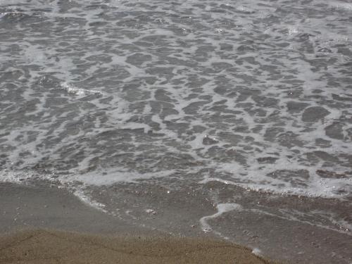 a close up of the sand and water on the beach at Kiknos Studios in Kalamaki Heraklion