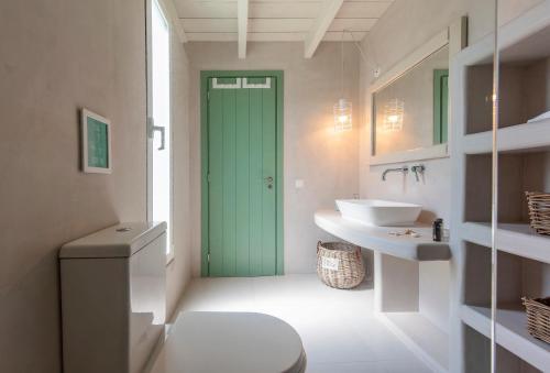 a bathroom with a green door and a sink at Ta Spitakia in Kos Town