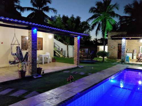 a swimming pool in front of a house at night at casa na praia de guajiru in Guajiru