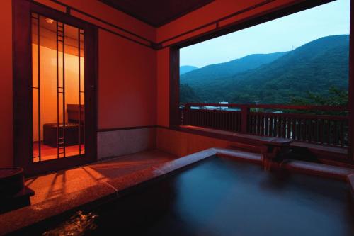 a room with a swimming pool and a large window at Hakone Onsen Ryokan Yaeikan in Hakone