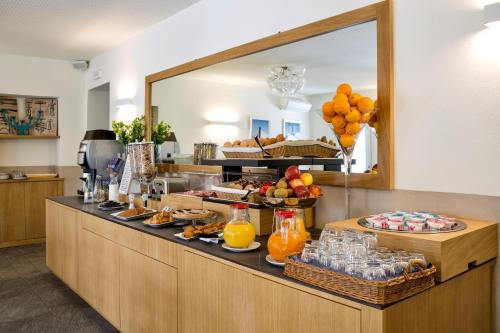 a buffet line with food and drinks and a mirror at Hotel Baia di Paré in Valmadrera