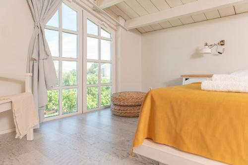 a white room with a bed and a large window at Ta Spitakia in Kos Town