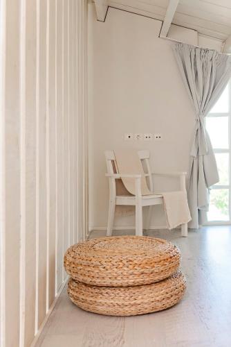 a white room with a chair and a ottoman at Ta Spitakia in Kos Town