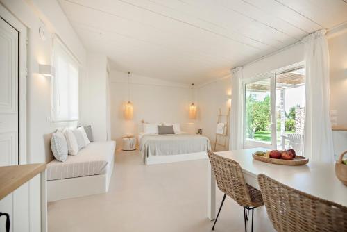 a white room with a bed and a table and chairs at Ta Spitakia in Kos Town