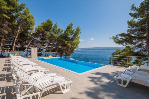 a villa with a swimming pool and lounge chairs at Villa Charlotte in Omiš