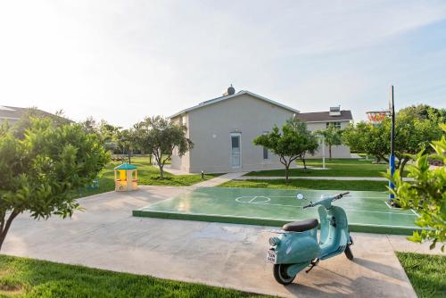 a scooter parked in a yard with a basketball hoop at Ta Spitakia in Kos Town