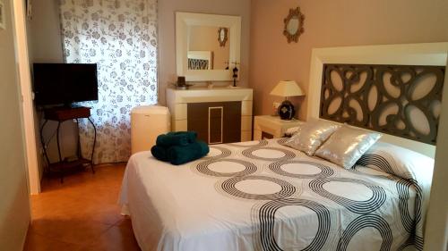 a bedroom with a large bed and a television at Precioso apartamento a pie de playa en la nueva Milla de Oro entre Estepona y Marbella in Estepona