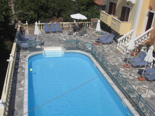 a large blue swimming pool with chairs and tables at Stella Apartments in Petra