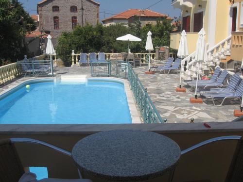 a swimming pool with chairs and umbrellas and a table at Stella Apartments in Petra