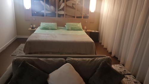 a bedroom with two beds and a couch in it at Flat Manaus in Manaus