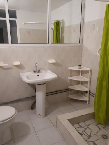 een witte badkamer met een wastafel en een toilet bij TI-WAIT in Sainte-Anne