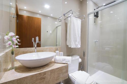 a bathroom with a sink and a toilet and a shower at Apto 2Q com varanda no Ed Maximum Home in Natal