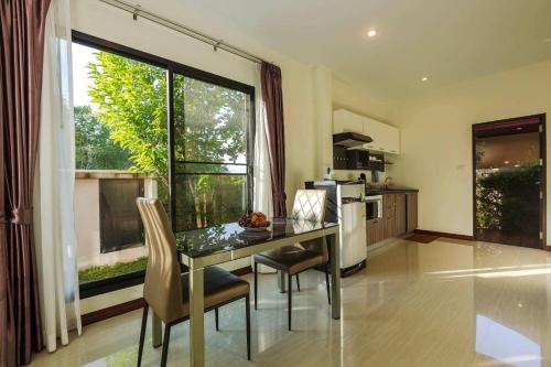 a kitchen with a table and chairs and a large window at Aonang Oscar Pool Villas - Free Shuttle to Aonang Beach -shared pool - private pool in Ao Nang Beach