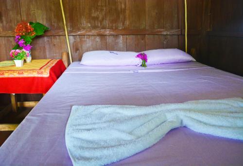 a bed with a blanket on it in a room at Posada El Esfuerzo in Nuquí